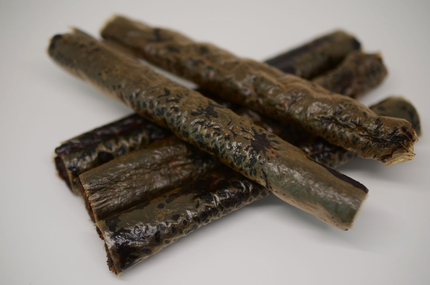 Beaver Roll Pet Treats on white background. Stacked in a pile.