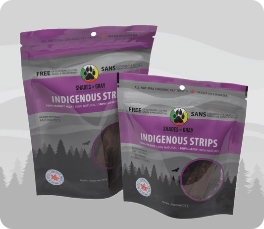 Image of Shades of Gray Indigenous Pet Treats' Indigenous Strips rabbit pet treats packaging, featuring two purple bags of rabbit strip pet treats. Each bag highlights 100% rabbit meat, raised without antibiotics, 100% natural, and free of glycerine, gluten, grain, and preservatives. 'Made in Canada' and 'Ontario' badges are visible, with a paw print logo and net weight of 100g or 70g