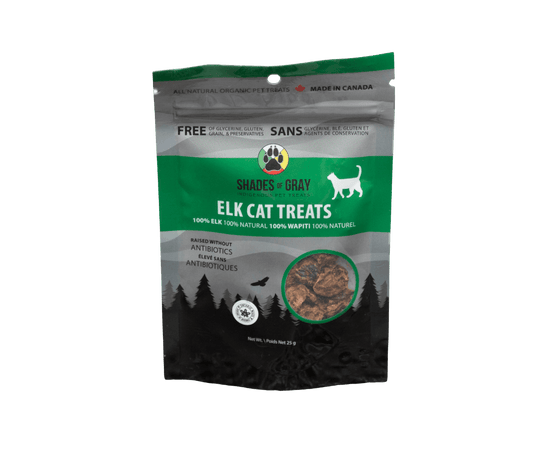 Front of Shades of Gray Indigenous Pet Treats Elk Cat Treats packaging in green, black and grey resealable pouch, featuring bold “ELK CAT TREATS” lettering, “Single Ingredient” callout, clear window showing small dehydrated elk pieces, Made in Ontario badge, Canadian flag, and circular Shades of Gray Indigenous Pet Treats logo.