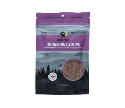 Image of Shades of Gray Indigenous Pet Treats' Indigenous Strips rabbit pet treats packaging, featuring 100g bag of rabbit strip pet treats. The text on bag highlights 100% rabbit meat, raised without antibiotics, 100% natural, and free of glycerine, gluten, grain, and preservatives. 'Made in Canada' and 'Ontario' badges are visible, with a paw print logo and net weight of 100g