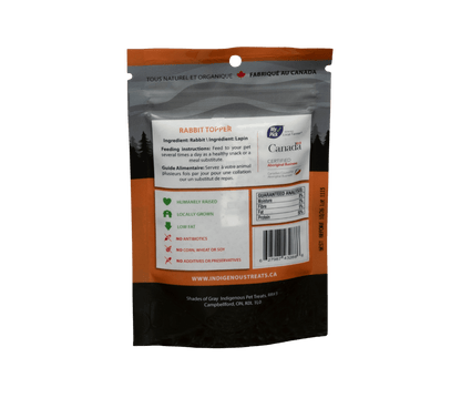 Rear panel of Shades of Gray Rabbit Topper bag in matte grey/orange design with white typography. Lists single ingredient: "Rabbit," full guaranteed analysis (e.g., protein 50%,  fat 9%, Fibre 3%, Moisture 8%), detailed feeding guidelines for dogs and cats by weight, safe handling and storage tips, barcode, net weight (3 oz), and a note on ethical Indigenous-sourced Canadian rabbit with the Shades of Gray logo and contact info.